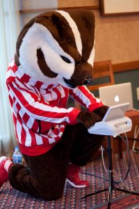 Bucky Badger using a stenography machine to make captioning. 
