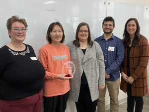 Kim Mueller with Forward in Access award and McBurney Center staff in a classroom
