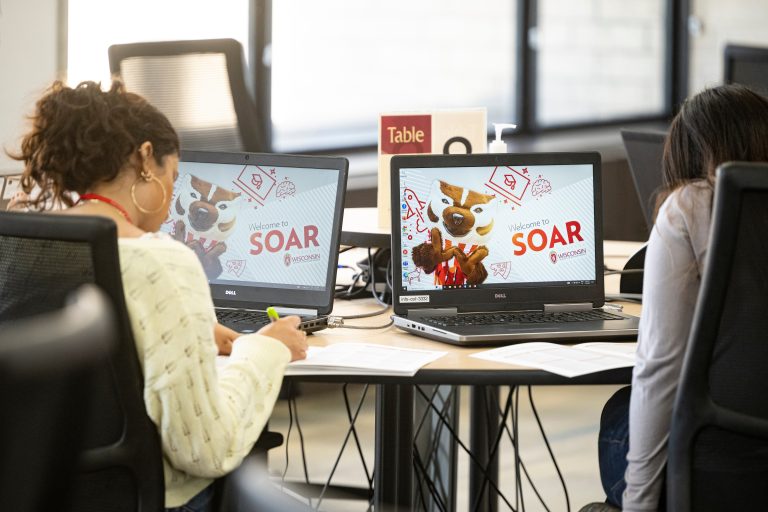 2 students attending SOAR choose their classes on a laptop screen.